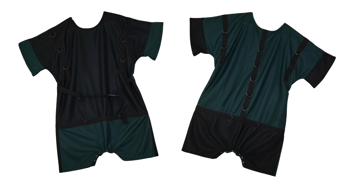Front and Rear view of a Black and Green romper with restraining rings hand made by the bears cave on a pink fluffy blanket