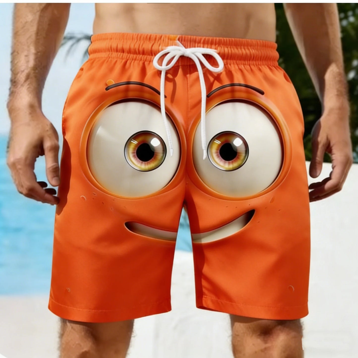 Orange shorts with cartoonish eyes and a mouth on a beach.