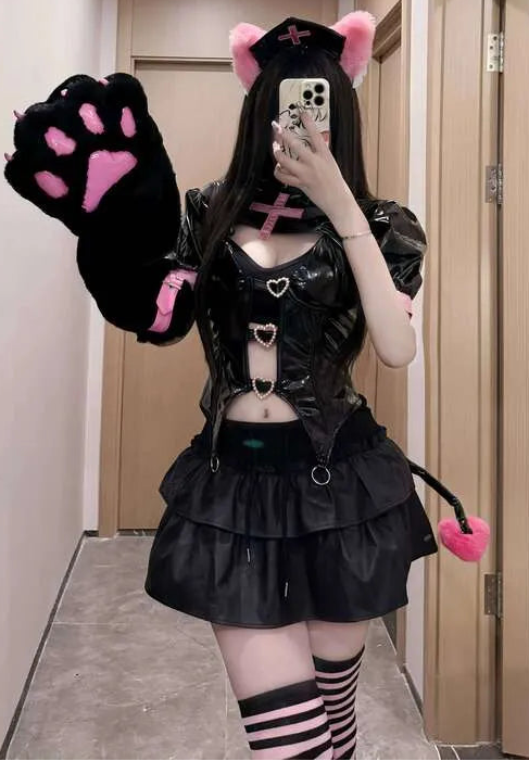 Person wearing a black leather outfit with pink accents in a hallway.