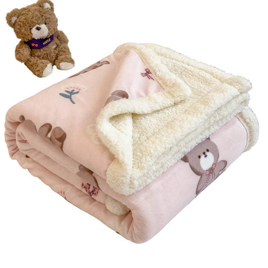 Pink blanket with teddy bear design on a bed