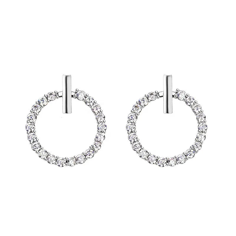 Pair of silver hoop earrings with clear gemstones on a white background