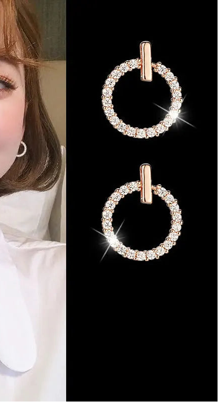 Woman wearing round earrings with a close-up of the earrings on a black background.