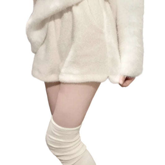 Person wearing a white fluffy coat and knee-high white socks in a room with a coat rack.