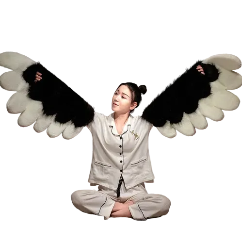 Person wearing fluffy angel wings in a bedroom setting