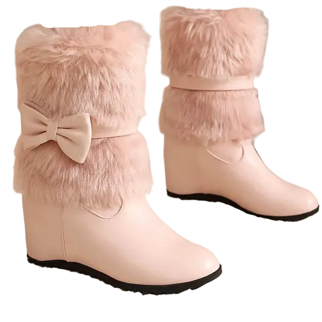 Pink winter boots with fluffy fur and a bow detail on a neutral background.
