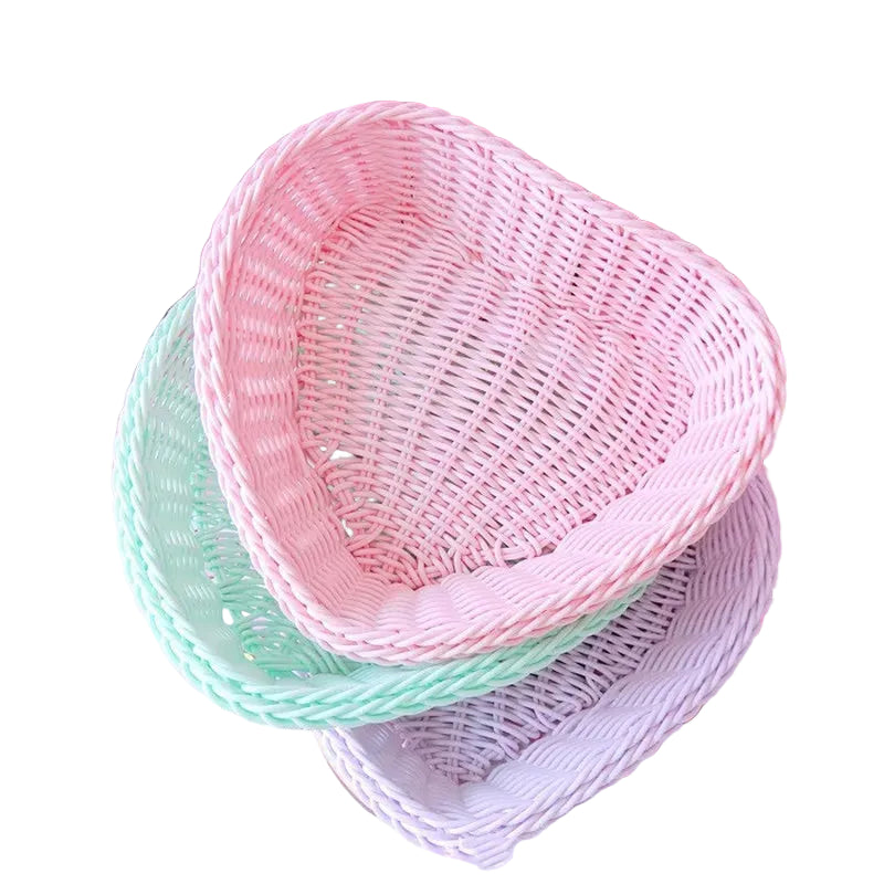 Stack of pastel-colored woven baskets on a pink background
