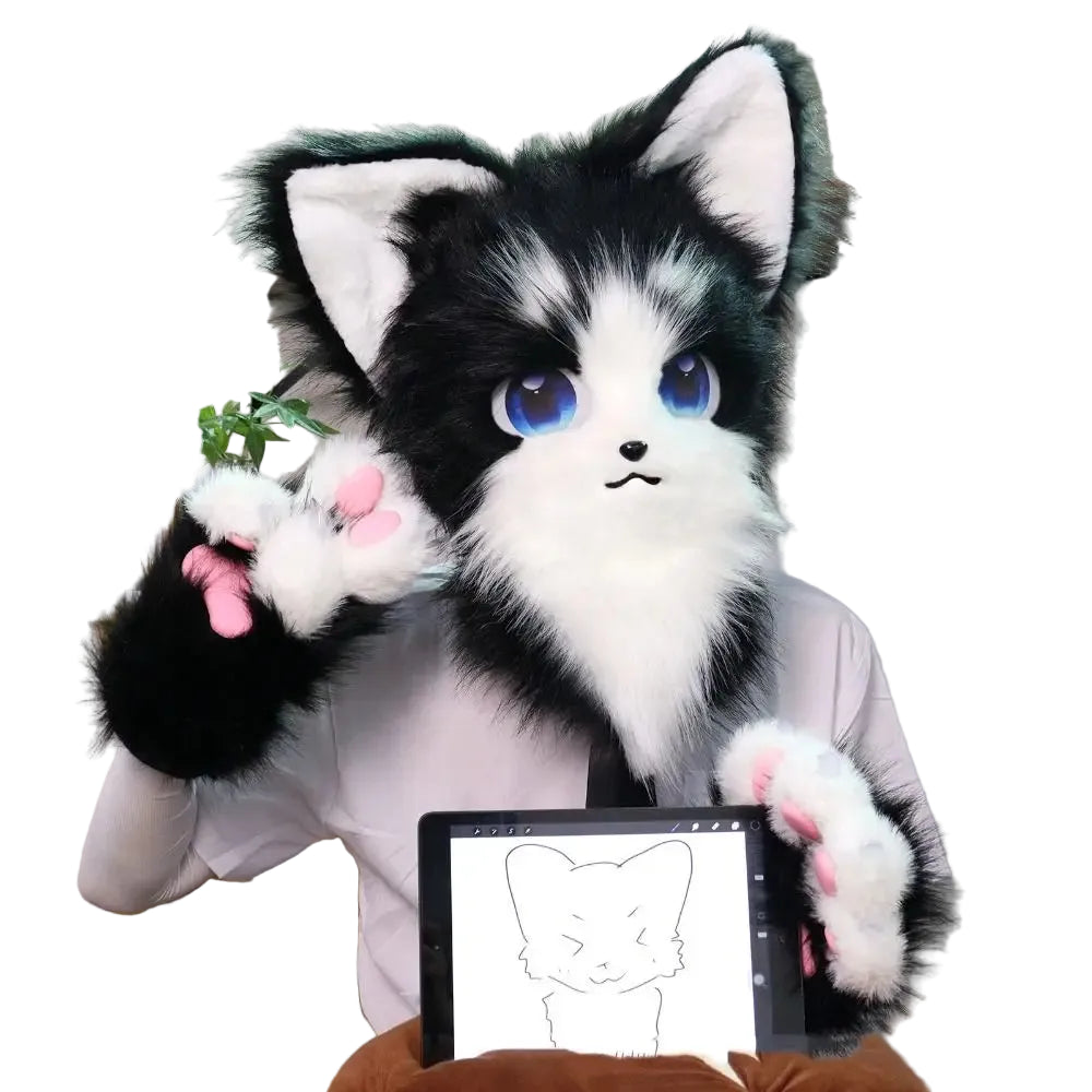Black and white plush cat toy with blue eyes sitting on a chair next to a tablet displaying a drawing of a cat.