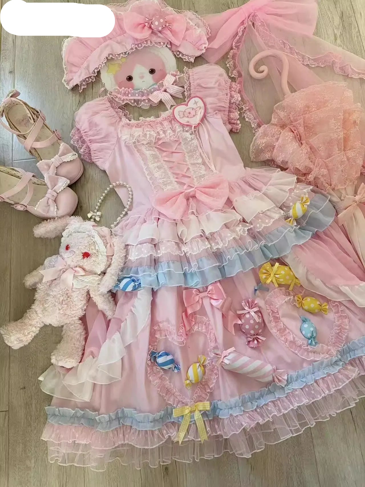 Pink ruffled dress with teddy bears and shoes on a wooden floor, brand 'Chimavvi' visible.