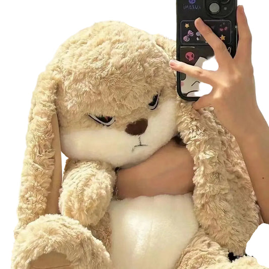 Person holding a large beige plush toy with a phone in the background