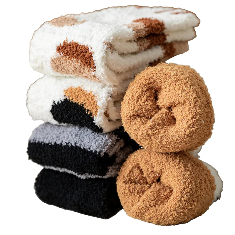 Stack of plush socks with a single sock in front on a soft surface
