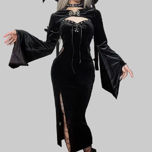 Person wearing a black velvet dress with long sleeves in a Halloween-themed room.