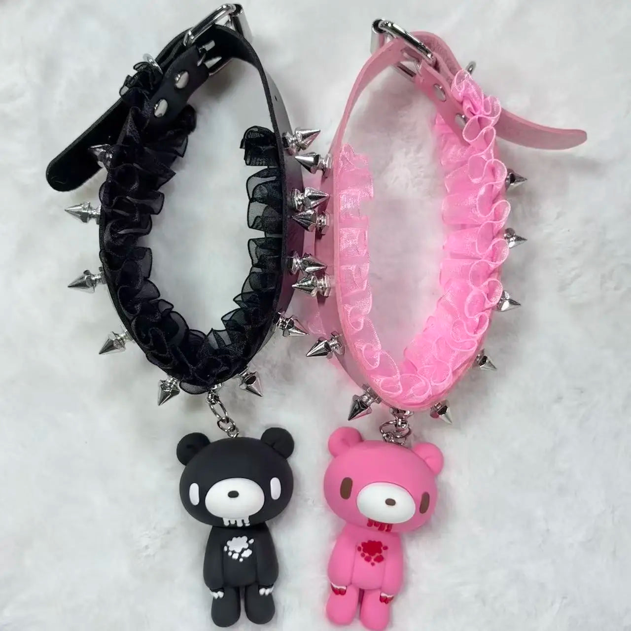 Black and pink chokers with spike details and bear charms on a white background