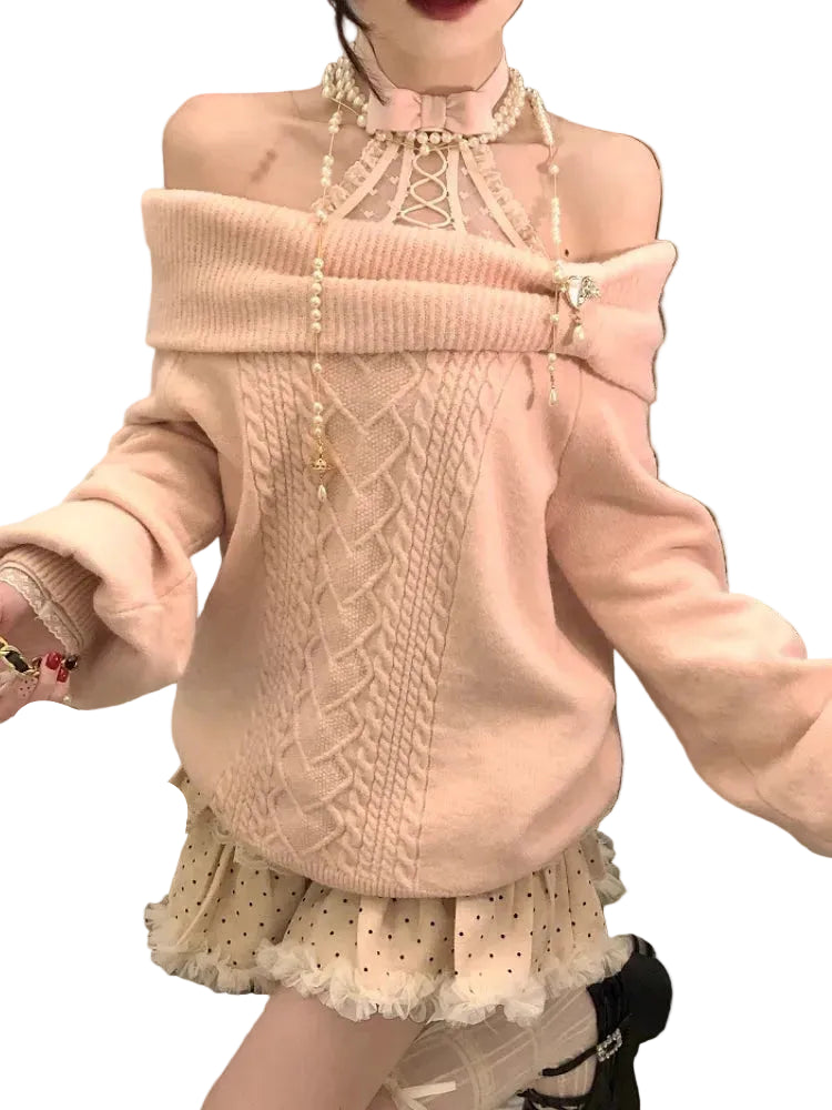 Person wearing a pink sweater with intricate patterns and a pearl necklace.