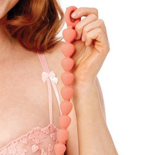 Woman wearing a pink lace bra and panties set on a white background
