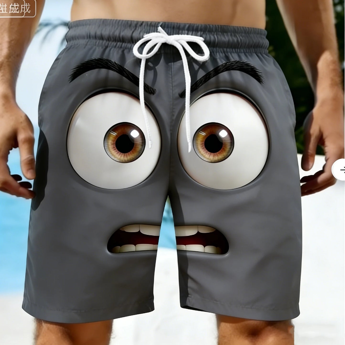 Gray shorts with cartoonish face design on a blurred beach background