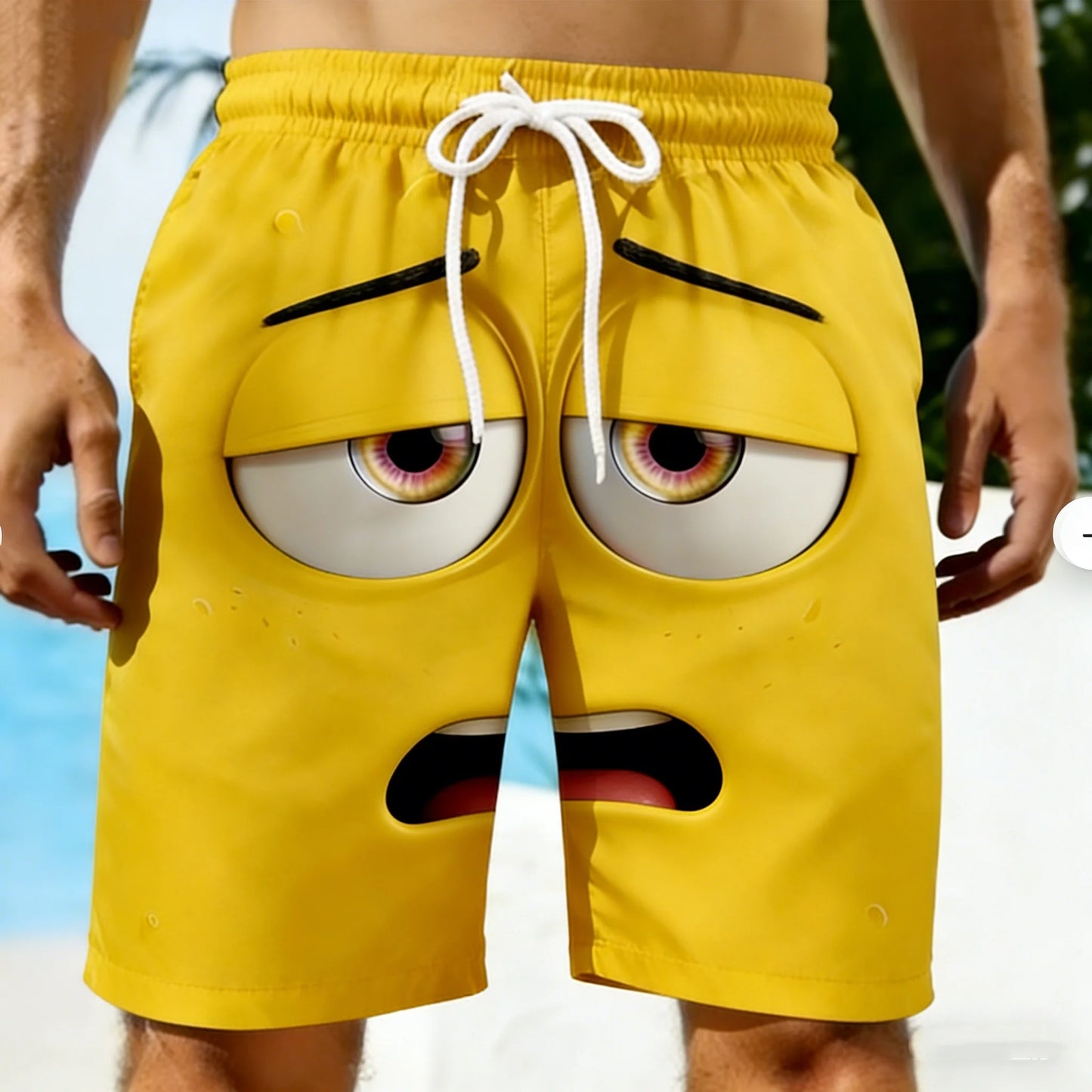 Yellow shorts with cartoon face design held by a person against a blurred background