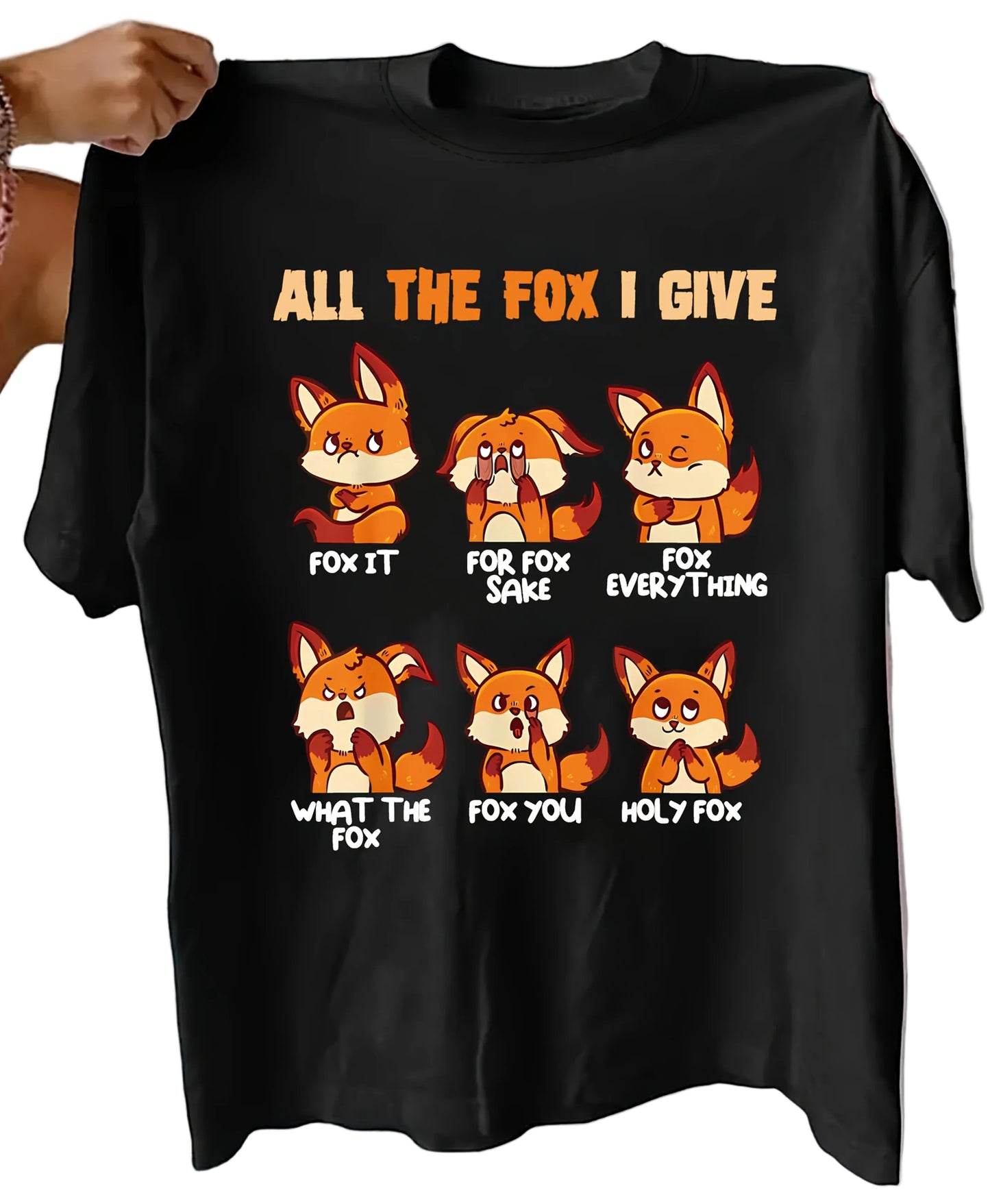 Black t-shirt with fox graphic and text held by a person on a bed.