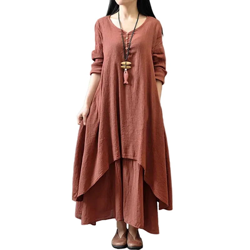 Person wearing a long rust-colored dress against a gray background