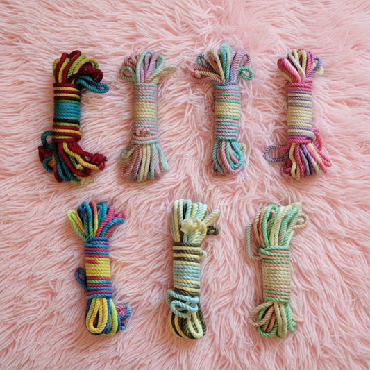 Set of colourful rope toys on a pink fluffy blanket background